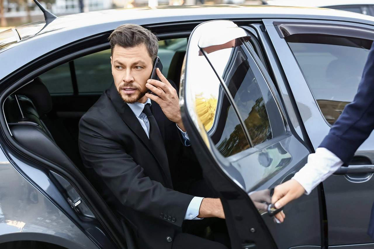 Businessman Exiting a Chauffeured Car